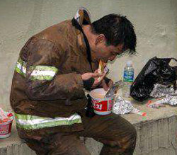 지난해 4월 부산 중고차매매단지 화재 현장에서 한 소방관이 그을음이 묻은 얼굴을 한 채 컵라면을 먹고 있다. 부산지방경찰청 페이스북 캡처