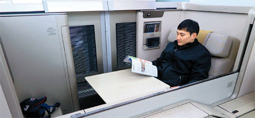 지난달 28일 본보 김성규 기자가 인천국제공항 인근 아시아나항공 격납고에서 아시아나의 일등석인 ‘퍼스트 스위트’를 체험하고 있다. 널찍한 접이식 테이블과 여닫을 수 있는 슬라이딩 도어가 눈에 띈다.