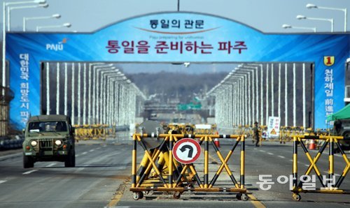 설 연휴 마지막 날인 10일 개성공단으로 이어지는 경기 파주시 통일대교 남단 도로에 군 관련 차량이 지나가고 있다. 통일대교의 바리케이드에 걸린 유턴 표지판이 되돌아가야 하는 남북 교류의 현주소를 보여주고 있다. 정부는 북한의 장거리 미사일 발사에 대응해 이날 개성공단 가동 전면 중단 조치를 발표했다. 파주=최혁중 기자 sajinman@donga.com