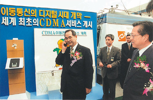 1996년 부호분할다중접속(CDMA) 세계 최초 상용화 기념식에서 이수성 전 국무총리(왼쪽)가 휴대전화로 통화하고 있다. CDMA는 한국전자통신연구원의 주요 연구성과 가운데 경제적 파급효과가 약 54조 원으로 가장 큰 것으로 분석된다. 한국전자통신연구원(ETRI) 제공