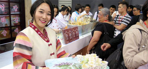 지난해 5월 홍콩에서 열린 홍콩식품박람회에 23개 국내 업체가 참가했다. aT는 해외에서 열리는 식품박람회에 국내 업체들이 참여할 수 있도록 예산을 지원했다. 한국인 모델이 외국인들에게 만두를 선보이고 있다. aT 제공