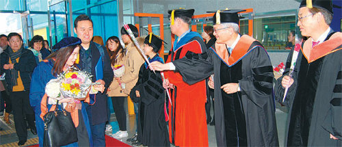 19일 열린 코리아텍(한국기술교육대) 학위수여식에서 김기영 총장(오른쪽에서 두 번째) 등 교수들이 도열한 채 졸업식장에 입장하는 학부모들에게 꽃을 선사하며 축하인사를 하고 있다. 코리아텍 제공