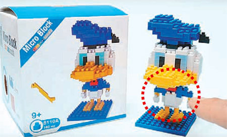 나노블록 부품이 모자라 그림과 실제 모형이 다른 점을 지적하는 동영상의 한 장면. 도널드덕 배 부분(점선 안)부품이 없어 다른 것으로 대체했다. 유튜브 영상 캡처