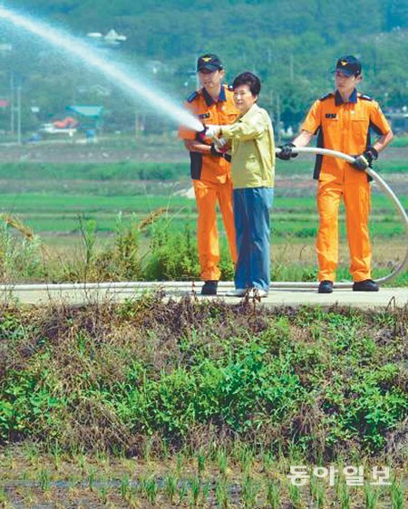 지난해 6월 가뭄 피해가 심각했던 인천 강화군 화도면 흥왕리에서 박근혜 대통령이 소방대원들과 함께 마른 논에 물을 뿌리고 있다. 동아일보DB