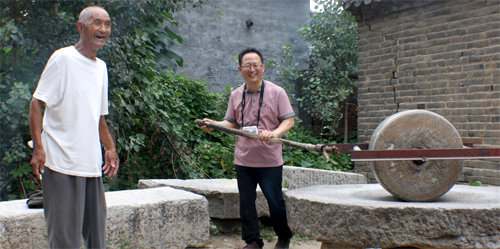 중국 산둥 성 쩌우청 시 맹자 고택 앞에서 오래된 방아 손잡이를 쥔 신정근 교수(오른쪽). 왼쪽 노인은 맹자의 74대 후손이라고 한다. h2 제공