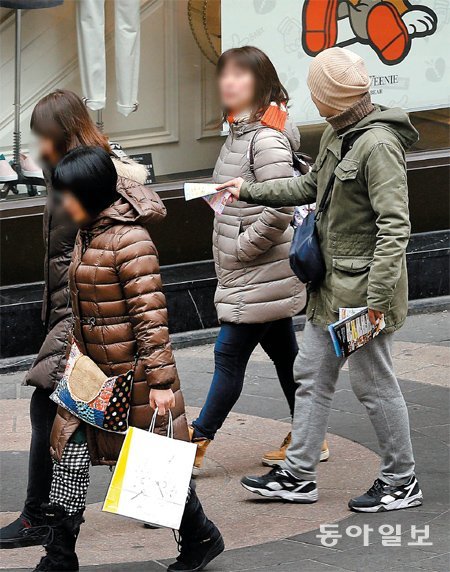 3일 서울 중구 명동 거리 한복판에서 두툼한 외투를 입고 모자를 쓴 아르바이트생이 지나가는 사람들에게 전단지를 나눠주고 있다. 전단지 배포 아르바이트생들은 2시간 단위로 시급을 계산해 시간당 1만 원 내외의 돈을 받는다. 양회성 기자 yohan@donga.com