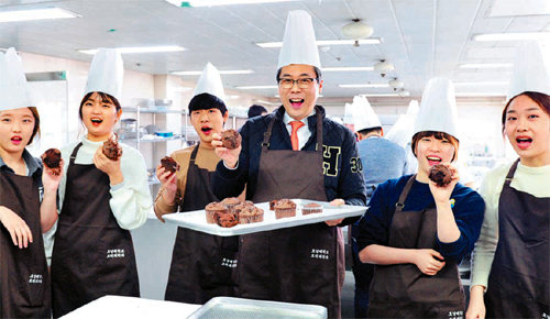 호남대 조리과학과 신입생들과 서강석 총장(오른쪽에서 세 번째)이 셰프 체험을 하면서 만든 초코머핀을 들고 활짝 웃고 있다. 호남대 제공