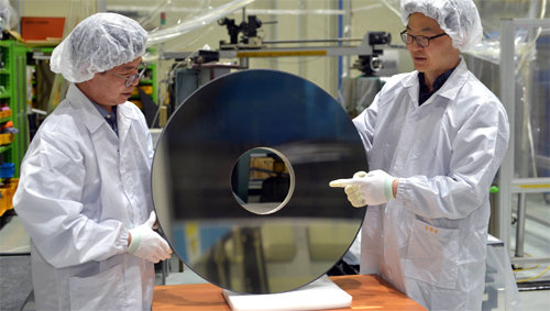 양호순 한국표준과학연구원 우주광학센터장(오른쪽)이 실리콘 카바이드를 이용해 독자 기술로 개발한 지름 700mm인 비구면 반사경에 대해 설명하고 있다. 한국표준과학연구원 제공
