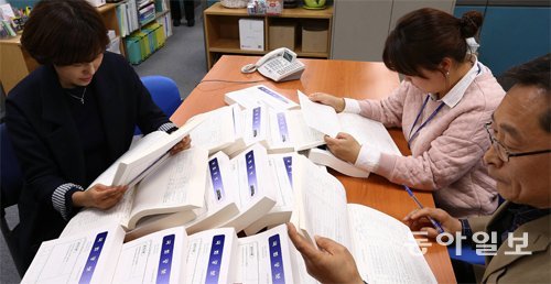 국회 사무처 직원들이 25일 공개된 ‘2016년 고위공직자 재산 신고 명세’가 담긴 국회관보를 살펴보고 있다. 전영한 기자 scoopjyh@donga.com