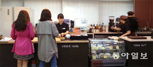 15일 서울 종로구 서울시교육청 본청 1층에 있는 장애학생 직업체험을 위한 장애인 운영카페 ‘꿈틀’에서 장애학생들과 사회복지사가 커피를 만들어 판매하고 있다. 임현석 기자 lhs@donga.com