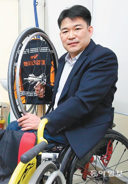 최근 소방관 복직이 확정된 최성찬 씨가 5년 만에 다시 입게 된 제복을 배경으로 휠체어 바퀴를 들고 웃고 있다. 고양=전영한 기자 scoopjyh@donga.com