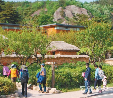 25일 오후 경남 김해시 진영읍 봉하마을을 찾은 관람객들이 노무현 전 대통령 사저(뒤쪽 건물)와 생가(초가집)를 밖에서 구경하고 있다. 강정훈 기자 manman@donga.com