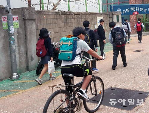 지난달 28일 서울 동대문구 숭인중 후문 앞 ‘아마존’으로 학생들이 등교하고 있다. 내년 8월이면 후문 바로 옆에 신축 아파트 
차량 출입구가 생길 예정이라 학교와 학부모들은 ‘통학로가 위험해진다’며 반발하고 있다. 이호재 기자 ho@donga.com