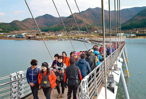 전남 강진군 가우도를 찾은 관광객들이 출렁다리를 건너고 있다. 전남도의 ‘가고 싶은 섬’에 선정된 가우도는 올 들어 18만3000명이 방문하는 등 강진의 대표 관광지로 부상했다. 강진군 제공