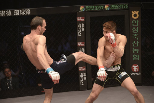 이윤준(오른쪽)이 14일 서울 장충체육관에서 열린 ‘샤오미 로드FC 031’ 페더급 경기서 조지 루프의 오른발 리버킥을 방어하고 있다. 루프는 1라운드 1분15초만에 리버킥 후 다리 골절을 당해 TKO로 졌다. 사진제공｜ 로드FC