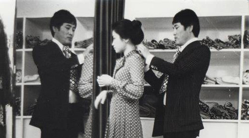1960년대 자신의 의상실에서 새로 만든 옷의 치수를 재고 있는 앙드레 김(오른쪽). 서울역사박물관 제공