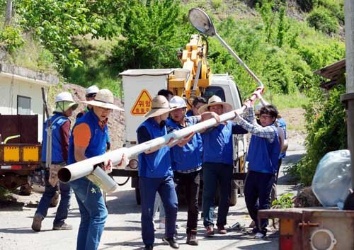 지난 12일 삼성전자 임직원들이 무주 호롱불 마을에서 노후 보안등을 수거하고 있다. 사진=삼성전자 제공
