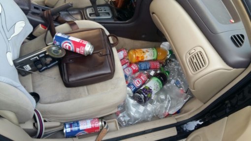 부탄가스를 입에 물고 차량을 운전한 혐의로 구속된 김 씨의 차량 조수석에 그가 흡입한 부탄가스 빈통 여러 개가 널려 있다. 서울 강북경찰서 제공