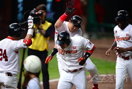 SK 최승준은 거포 유망주로 평가받았으나 잠재력을 터트리지 못하고 지난 시즌이 끝난 뒤 LG에서 SK로 이적했다. 그런 그가 18일 롯데와 홈경기에서 7회말 대타로 나서 만루홈런을 터트리며 활짝 웃었다. 홈런을 친 뒤 동료들의 환영을 받고 있는 최승준(가운데). 문학｜김민성 기자 marineboy@donga.com