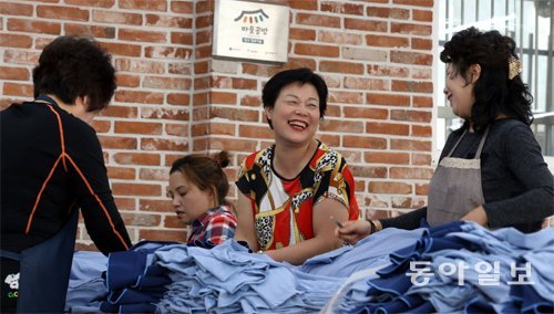 지난달 28일 서울 중랑구 마을공방에서 여성들이 환한 표정으로 봉제 마무리 작업을 하고 있다. 마을공방은 정규직 근무가 어려운 경력단절 여성을 위한 일터다. 최혁중 기자 sajinman@donga.com