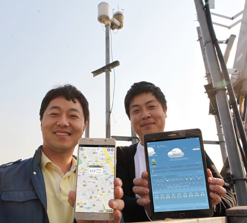 SK테크엑스 직원들이 기지국에 설치된 기상센서 앞에서 IoT 네트워크를 활용한 기상 정보를 체크하고 있다. 사진=SK텔레콤 제공