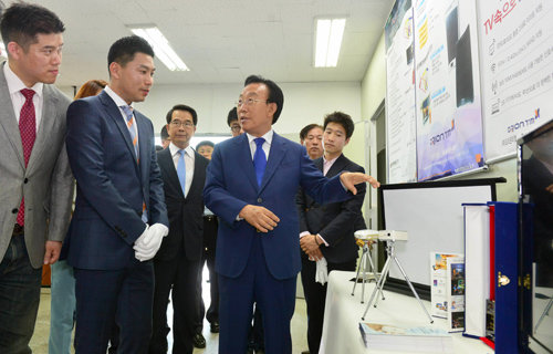 김관용 경북도지사가 19일 구미국가산업단지에 있는 오리온티엠을 방문해 장희석 대표(왼쪽에서 두 번째)와 제품에 대한 이야기를 나누고 있다. 경북도 제공