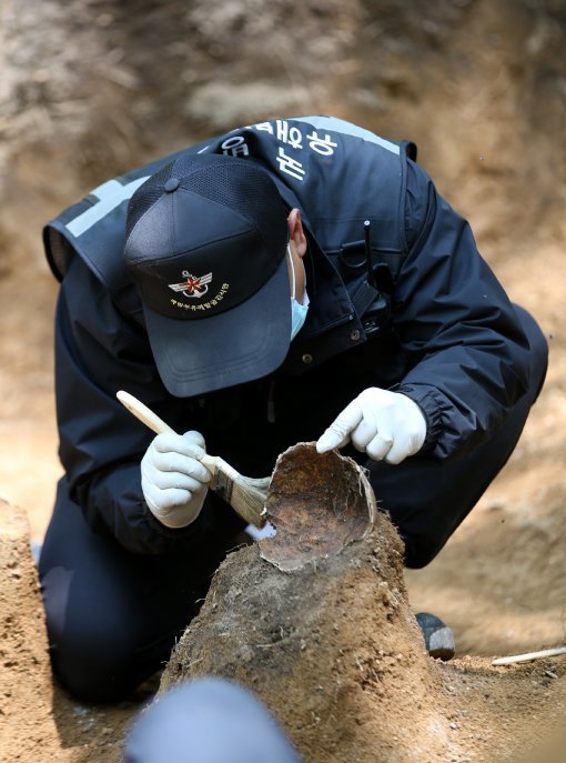 국방부 유해발굴감식단 장병이 23일 오후 강원도 인제 덕적리 가리봉 1050고지에서 6.25전쟁 전사자 유해를 수습하고 있다. 가리봉 지역은 1951년 5월 15일부터 17일까지 아군 수도사단과 3사단이 적군 6사단및 12사단과 격전을 벌였던 곳으로 국방부 유해발굴감식단은 이곳에서 이날까지 3년간 21구의 6.25전쟁 전사자 유해를 수습했다.
