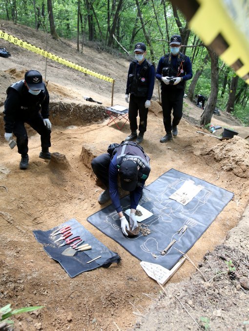 국방부 유해발굴감식단 장병이 23일 오후 강원도 인제 덕적리 가리봉 1050고지에서 6.25전쟁 전사자 유해를 수습하고 있다. 가리봉 지역은 1951년 5월 15일부터 17일까지 아군 수도사단과 3사단이 적군 6사단및 12사단과 격전을 벌였던 곳으로 국방부 유해발굴감식단은 이곳에서 이날까지 3년간 21구의 6.25전쟁 전사자 유해를 수습했다.