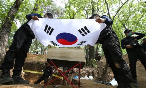 국방부 유해발굴감식단 장병이 23일 오후 강원도 인제 덕적리 가리봉 1050고지에서 6.25전쟁 전사자 유해를 수습하고 있다. 가리봉 지역은 1951년 5월 15일부터 17일까지 아군 수도사단과 3사단이 적군 6사단및 12사단과 격전을 벌였던 곳으로 국방부 유해발굴감식단은 이곳에서 이날까지 3년간 21구의 6.25전쟁 전사자 유해를 수습했다.