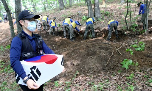 국방부 유해발굴감식단 장병이 23일 오후 강원도 인제 덕적리 가리봉 1050고지에서 6.25전쟁 전사자 유해를 수습하고 있다. 가리봉 지역은 1951년 5월 15일부터 17일까지 아군 수도사단과 3사단이 적군 6사단및 12사단과 격전을 벌였던 곳으로 국방부 유해발굴감식단은 이곳에서 이날까지 3년간 21구의 6.25전쟁 전사자 유해를 수습했다.