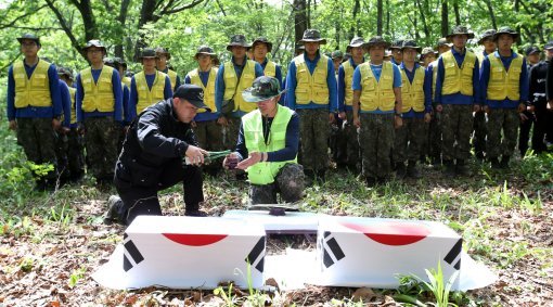 국방부 유해발굴감식단 장병이 23일 오후 강원도 인제 덕적리 가리봉 1050고지에서 6.25전쟁 전사자 유해를 수습하고 있다. 가리봉 지역은 1951년 5월 15일부터 17일까지 아군 수도사단과 3사단이 적군 6사단및 12사단과 격전을 벌였던 곳으로 국방부 유해발굴감식단은 이곳에서 이날까지 3년간 21구의 6.25전쟁 전사자 유해를 수습했다.