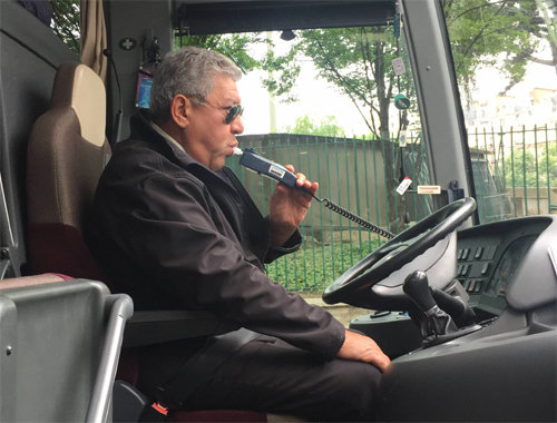 프랑스 파리의 관광버스 기사인 압델 라샤르 씨가 시동을 켜기 전 음주측정기를 불고 있다. 운전기사가 기준치 이상의 술을 마신 것으로 드러나면 버스의 시동은 켜지지 않도록 설계돼 있다. 손해보험협회 제공
