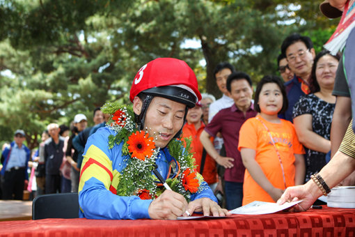 ‘그 어려운 걸 자꾸 해냅니다. 제가…’ 박태종 기수가 지난 21일 2000승의 대기록을 작성한 뒤 팬들에게 사인을 해주고 있다. 박 기수는 “말을 탈 수 있는 한 기수로서 경주로를 달리겠다”고 향후 목표를 밝혔다. 사진제공｜한국마사회