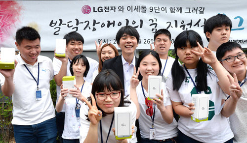 이세돌 9단(가운데)이 26일 서울 노원구 노원로 성민복지관에서 열린 ‘발달장애인의 꿈 지원식’ 행사에서 학생들에게 LG전자 스마트폰 ‘G5’를 선물한
뒤 기념사진을 찍고 있다. LG전자 제공