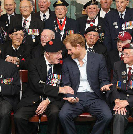 노타이 차림의 해리 왕자가 노르망디 상륙작전 당시 영국 해협을 건널 때의 분위기를 묻자 노병이 왕자의 팔을 잡고 이야기해주고 있다. 영국 데일리메일 홈페이지 캡처