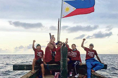 중국과 영토 분쟁을 벌이고 있는 스카버러 섬에 상륙해 필리핀 국기를 꽂는 데 성공한 필리핀 청년들이 12일 주먹을 들고 기뻐하고 있다. 사진 출처 홍콩프리프레스