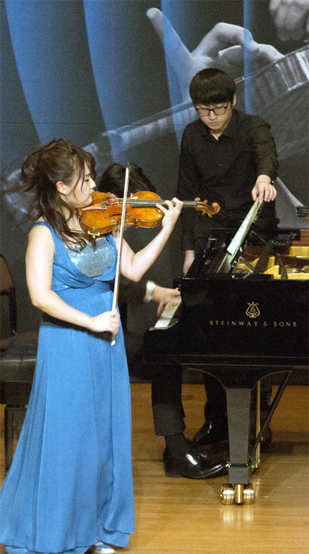 바이올리니스트 임지영의 공연에서 피아노 연주자의 뒤에 있는 페이지 터너(뒤). 금호아시아나재단 제공