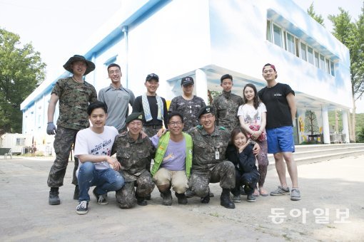 벽화작업을 이끈 조효건 부대장(아랫줄 오른쪽에서 두 번째)과 문정덕 화백(아랫줄 가운데), 그리고 함께 작업한 병사와 자원봉사자들. 사진 지호영 기자