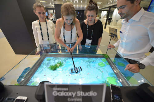갤럭시 스튜디오에서 관람객들이 ‘갤럭시 S7’의 방수 방진 기능을 활용해 물고기 잡기 체험을 하는 모습.