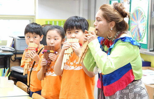 서울 양천구의 ‘월드 알리미’로 활동 중인 로사노 파우카르 야넷 씨(오른쪽)가 학생들과 페루 전통악기 ‘삼포냐’를 불고 있다. 이날 학생들은 전통악기를 연주하고 전통의상을 입어보며 다문화를 체험했다. 양천구 제공