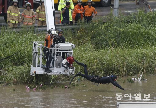 5일 서울지역 집중호우로 중랑천이 범람하면서 동대문구 군자교 인근 하천으로 시설물이 떠내려오자 서울소방본부가 인양 작업을 하고 있다. 사진 동아일보