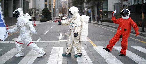 지웅배 씨(가운데)가 일반인들에게 우주와 천문학을 쉽게 전달하기 위해 우주복을 입고 행위예술을 하고 있다. 우주라이크 제공