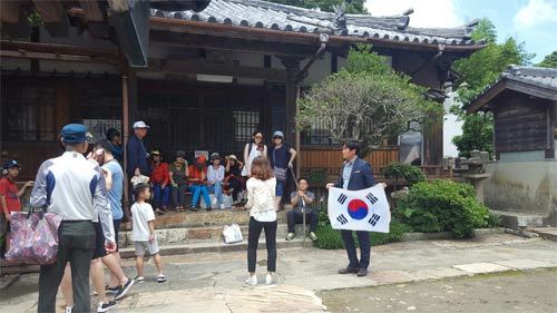 발해투어를 통해 대마도를 여행 중인 한국 관광객이 안내원으로부터 설명을 듣고 있다. 발해투어는 대마도에서 태극기를 들고 관광하는 회사로 유명하다. 발해투어 제공