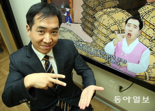 구철영 위례스터디연구소 원장이 서울 서초구 국립 중앙도서관에서 자신이 감수하고 출연한 수화영상도서 영상 앞에서 수화로 수화영상도서를 설명하고 있다. 양회성 기자 yohan@donga.com