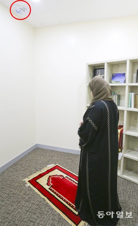 한 이슬람 여성이 서울대병원 무슬림 기도실 천장에 그려진 화살표(메카가 있는 방향·동그라미 부분)를 향해 기도하고 있다. 국내 대형 병원들은 앞다퉈 ‘큰손’ 중동 환자들의 편의를 위한 시설을 설치하고 있다. 원대연 기자 yeon72@donga.com