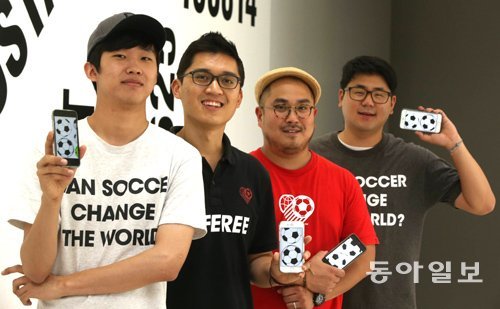 비카인드의 이하람 PD, 김동준 대표, 최준렬 작가, 최준우 이사(왼쪽부터)가 축구공이 그려진 휴대전화를 들고 활짝 웃고 있다. 이들은 유명 축구 선수들과 함께 소아암 어린이를 돕는 기부 캠페인 ‘슛포러브’를 진행하고 있다. 박영대 기자 sannae@donga.com