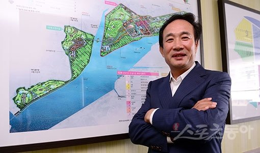 4월 오픈한 현대 솔라고 컨트리클럽은 개장하자마자 ‘다시 찾고 싶은 골프장’으로 입소문을 타고 있다. 골프 경력 30년의 박경재 회장은 “골퍼들의 편안한 안식처 될 수 있도록 최선의 서비스를 다하겠다”고 자랑했다. 골프장이 들어선 충남 태안 기업도시 조감도 앞에서 포즈를 취하고 있는 박 회장. 김종원 기자 won@donga.com