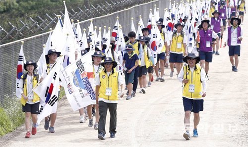 ‘제3회 대학생 DMZ 통일발걸음’에 참가한 탈북 대학생, 한국 대학생, 외국인 유학생 등 80여 명이 21일 경기 파주시 임진각 민통선 지역 철조망을 따라 걷고 있다. 이들은 이날부터 7박 8일 동안 중부전선 최북단 100km를 행진한다. 파주=양회성 기자 yohan@donga.com