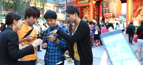 22일 일본 도쿄의 관광 명소 아사쿠사 가미나리몬 앞에서 시민들이 스마트폰을 들고 ‘포켓몬 고’ 게임을 즐기고 있다. 아사히신문 제공