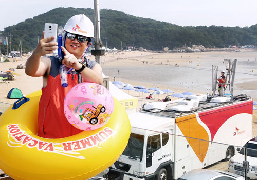 SK텔레콤 직원들이 26일 하계 휴가철을 대비해 인천 중구 을왕리 해수욕장에서 운용중인 이동기지국 장비를 특별 점검하고 있다.